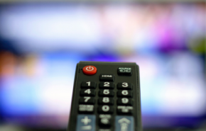 Photographie d'une télécommande devant une télévision